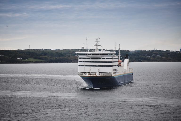 The Marine Atlantic Highlanders ferry flanked by green tree-covered shores.